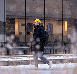 student walking on campus in the snow