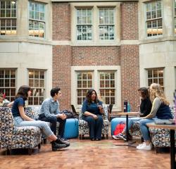A group of students in lounge chairs with a faculty member in the Michigan Union