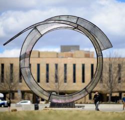 Looking through the Arriving Home circular glass sculpture to the School of Dentistry building