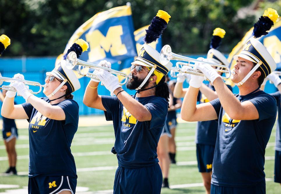 Members of the Michigan Marching Band practice on the field at Elbel Field on a Summer morning.