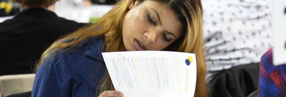 A student looking through papers in a classroom