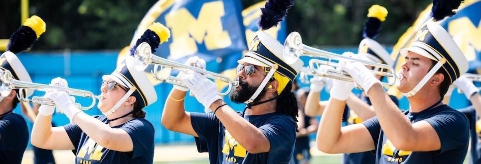 Members of the Michigan Marching Band practice on the field at Elbel Field on a Summer morning.