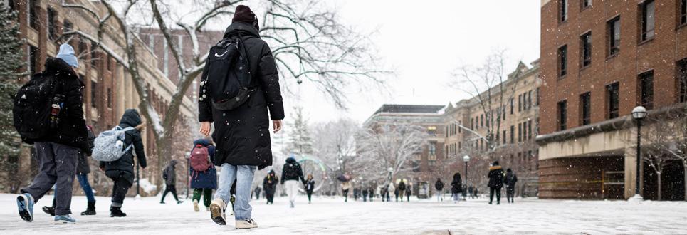 students walking across campus in the snow