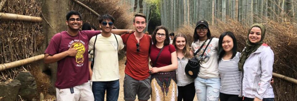 group of studies standing on a bridge